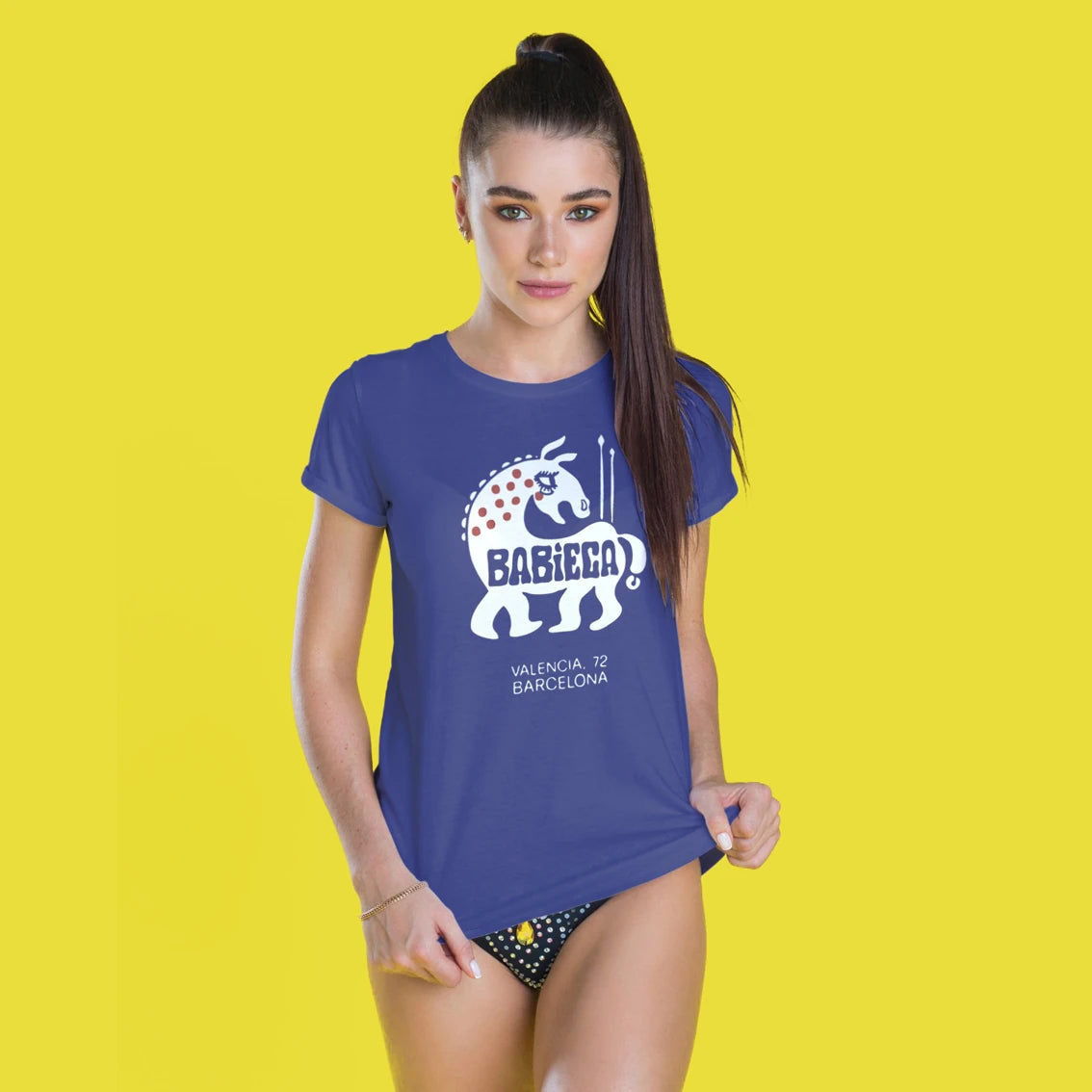 A woman is wearing a blue t-shirt with a graphic design of Babieca horse and 'Babieca - Valencia, 72 Barcelona' text on a yellow background