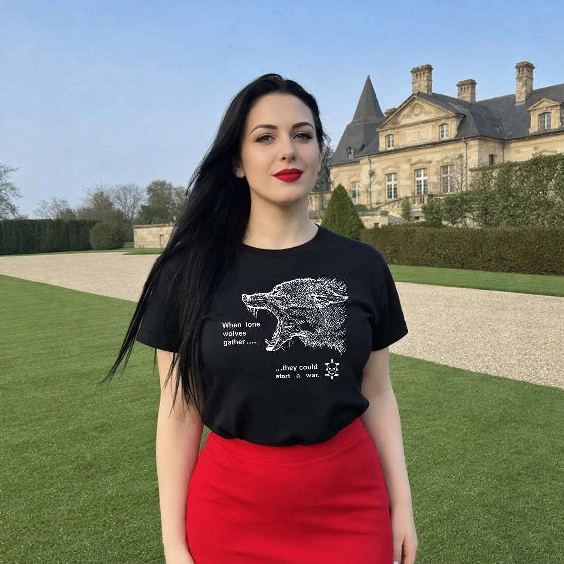 A woman wearing a black t-shirt with a graphic design of a wolf and text saying 'When lone wolves gather...they could star a war' in front of a large building.