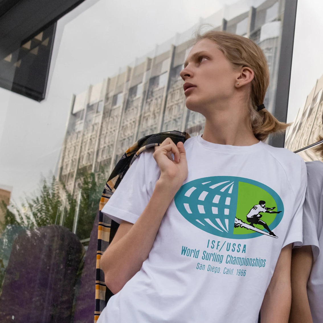 Man wearing a white World Surfing Championships t-shirt in an urban setting