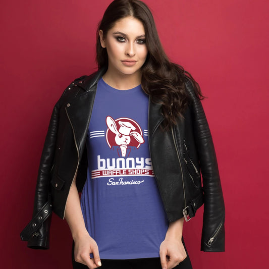 A woman is wearing a blue t-shirt with a logo of bunny dressed like a chef and 'Bunny's Waffle Shops, San Francisco' text on a red background