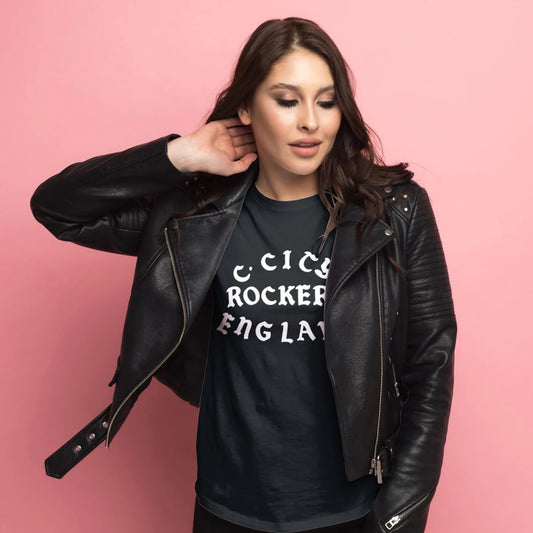 A woman is wearing a black leather jacket and black t-shirt with 'C. CITY ROCKERS, ENGLAND' text on a pink background
