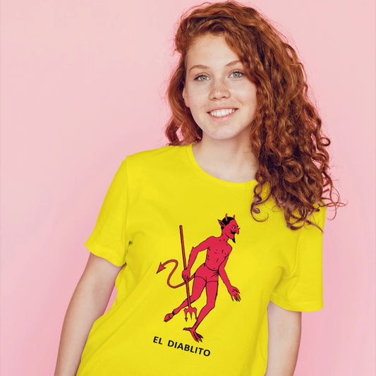 A woman is wearing a yellow t-shirt with a red devil graphic and 'EL DIABLITO' text on a pink background