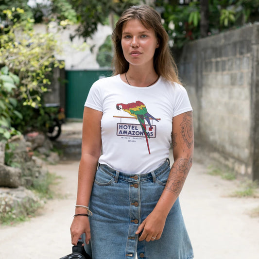 A woman is wearing a white t-shirt with a graphic design of a parrot and text saying 'Hotel Amazonas' standing outdoors