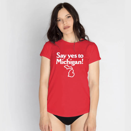 A woman is wearing a red t-shirt with 'Say yes to Michigan!' text and Michigan map on it against a plain background