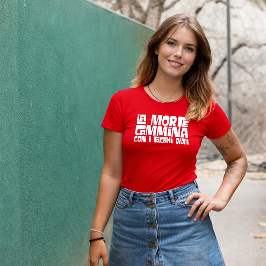Woman wearing a red t-shirt with a 'La Morte Cammina Con I Tacchi Alti' text against a green wall.
