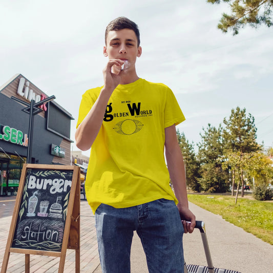 Man wearing a yellow t-shirt with 'Golden World Records' text, standing outdoors near a fast-food restaurant.