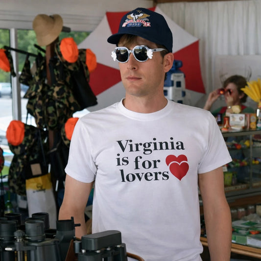 Man wearing a white t-shirt with 'Virginia is for lovers' text and a heart symbol, standing in a store.