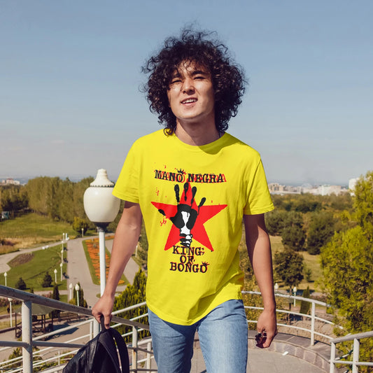 Man wearing a yellow t-shirt with a hand & star graphic design and 'MANO NEGRA - King Of Bongo' text outdoors