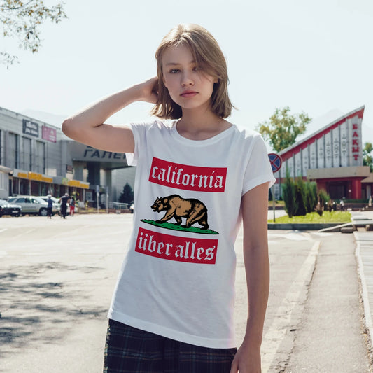Woman wearing a white t-shirt with a graphic design and 'California Über Alles' text in an outdoor setting