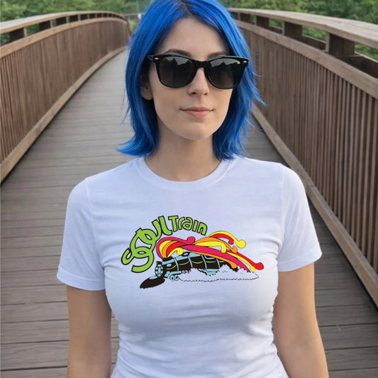 Woman in sunglasses wearing a white t-shirt with a colourful graphic design and 'Soul Train' text on a wooden bridge.