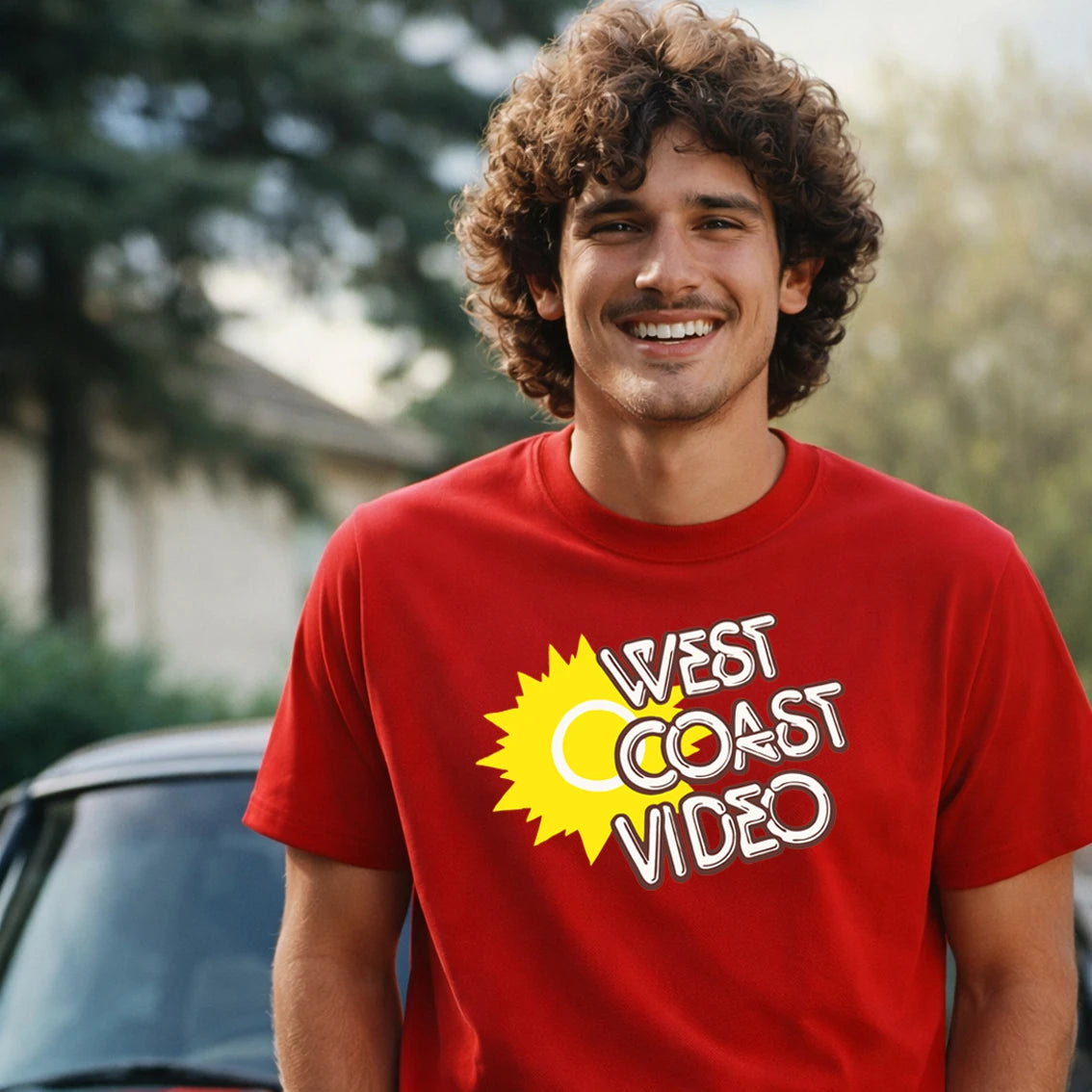 Man wearing a red 'West Coast Video' t-shirt with a yellow sun graphic.