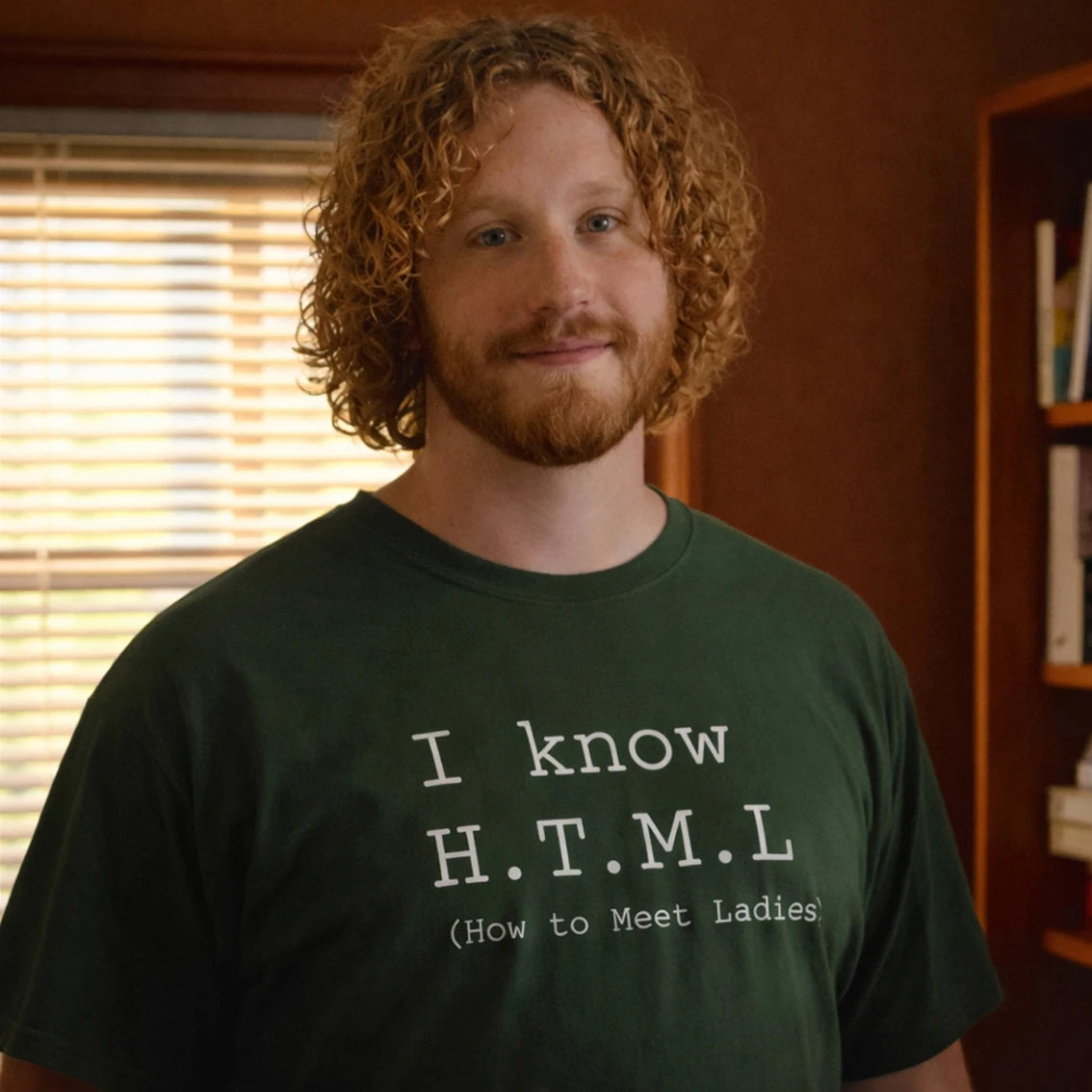 Man wearing a green t-shirt with 'I Know HTML' text standing in a room with a window and bookshelf.