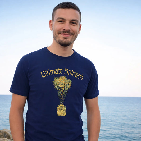Man wearing a navy blue t-shirt with 'Ultimate Spinach' design by the ocean