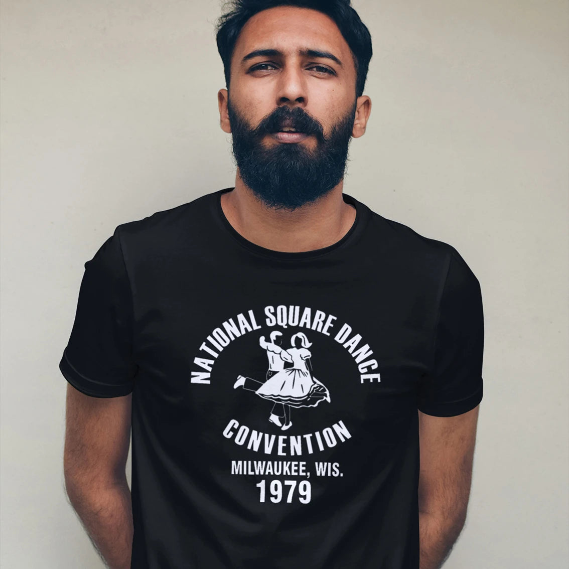 Man wearing a black t-shirt with a vintage dance convention design and 'National Square Dance Convention, Milwaukee, Wis. 1979' text against white background.