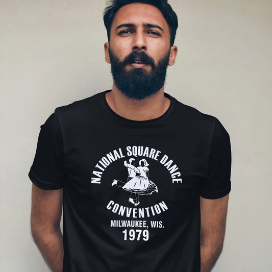 Man wearing a black t-shirt with a vintage dance convention design and 'National Square Dance Convention, Milwaukee, Wis. 1979' text against white background.
