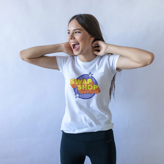 Man wearing a white t-shirt with 'Swap Shop' graphic design on a plain background