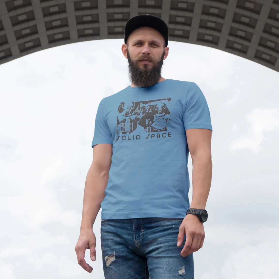 Man wearing a blue t-shirt with text 'Solid Space' and graphics, standing against a white background.