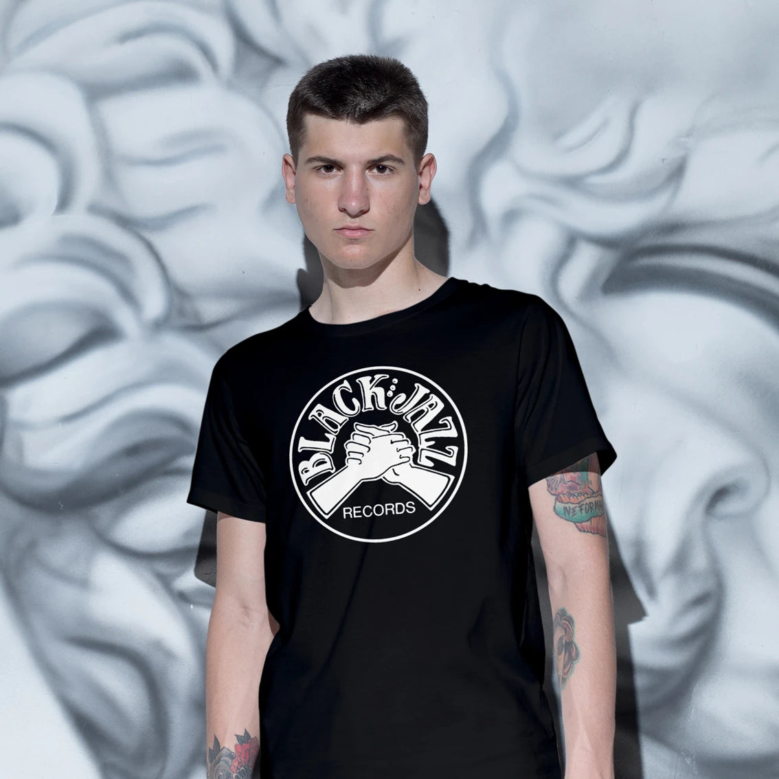 Man wearing a black t-shirt with 'Black Jazz Records' logo against a textured gray background